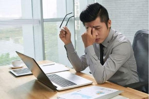 Man suffering from eye strain at a computer